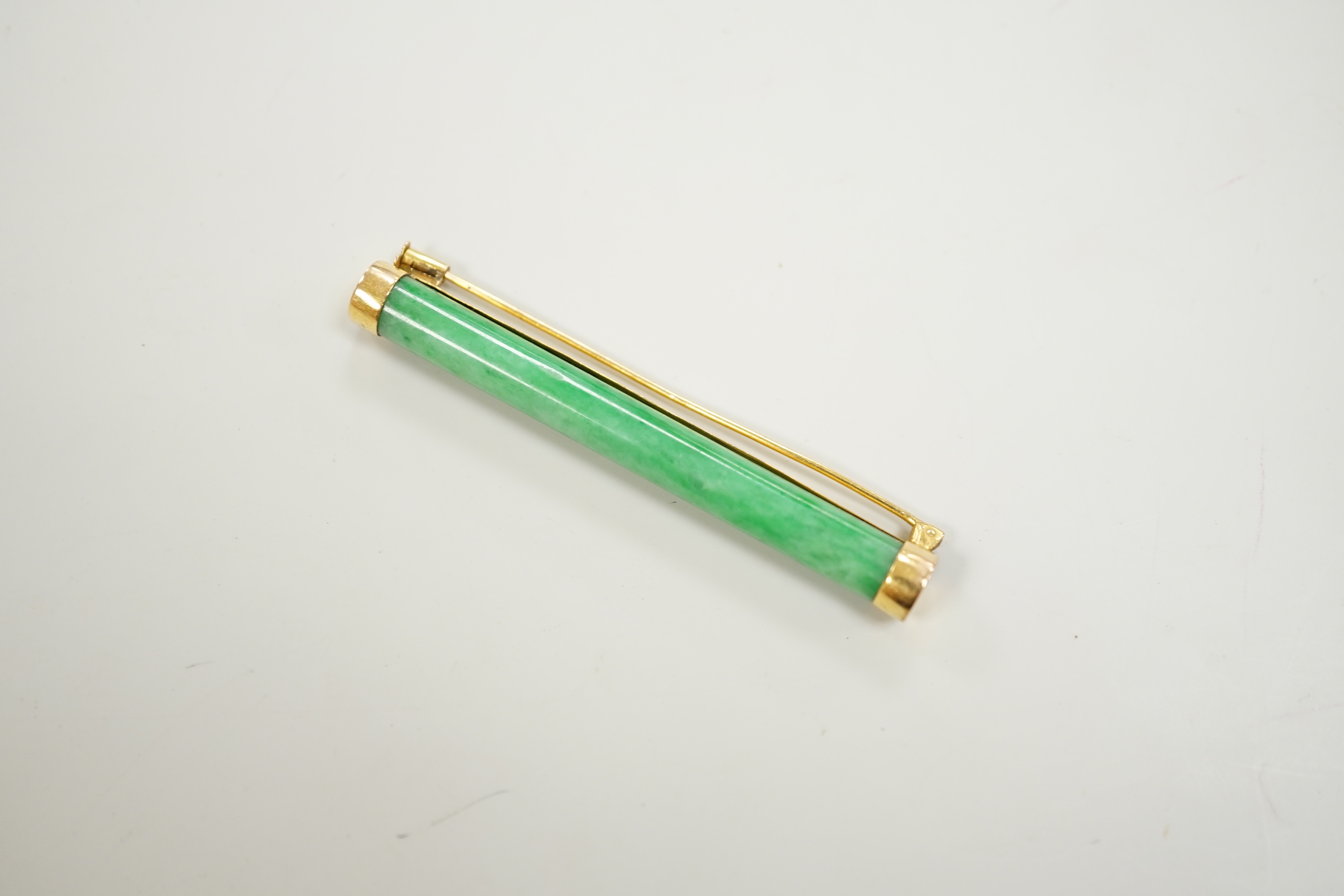 A Chinese yellow metal and cylindrical jade set bar brooch, 53mm, gross 5.6 grams.